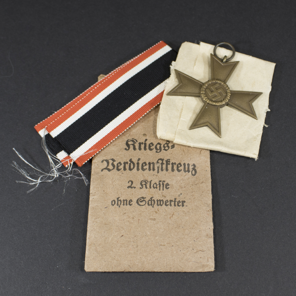 German War Merit Cross without swords, displayed with its original paper bag.