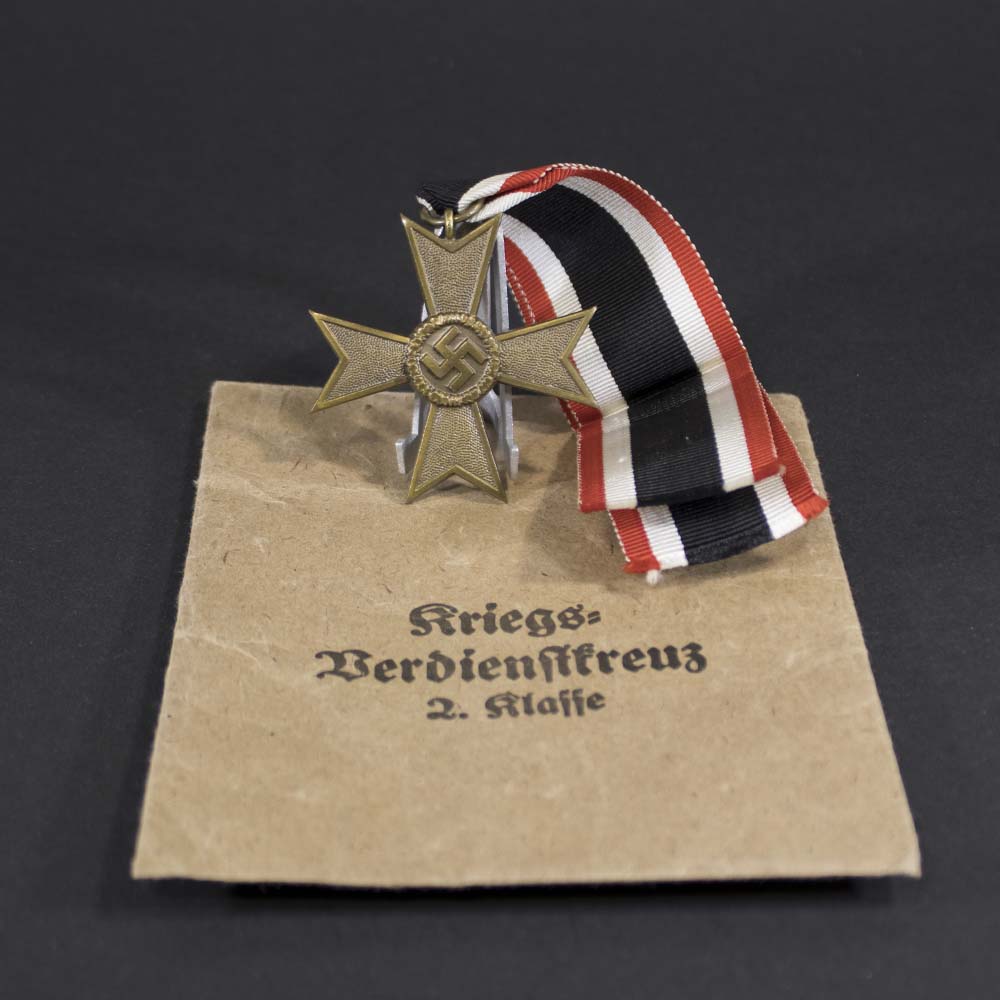 War Merit Cross without swords displayed alongside its original “Petz & Lorenz” packet, highlighting the complete set in preserved condition.