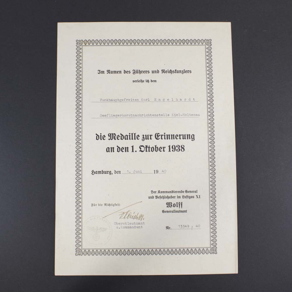 Official award certificate for the 1 October 1938 Sudetenland Commemorative Medal, featuring printed German text, official stamps, and a signature, recognizing participation in the occupation of the Sudetenland.