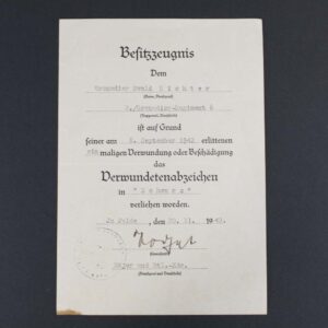 Front side of the award document for the Black Wound Badge, featuring printed German text, official stamps, and a handwritten signature, recognizing a soldier’s injury sustained in combat.