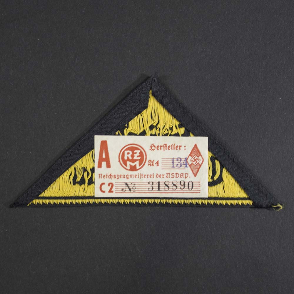 Reverse side of the Hitler Youth District Triangle, displaying the original RZM label still attached, indicating authenticity and mint condition.