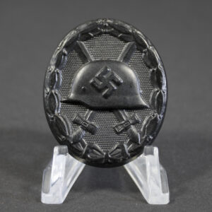 Full front view of a black German Wound Badge (Verwundetenabzeichen) in excellent condition, oval shape with embossed helmet and crossed swords.