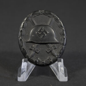 Full front view of a black German Wound Badge (Verwundetenabzeichen) in excellent condition, oval shape with embossed helmet and crossed swords.