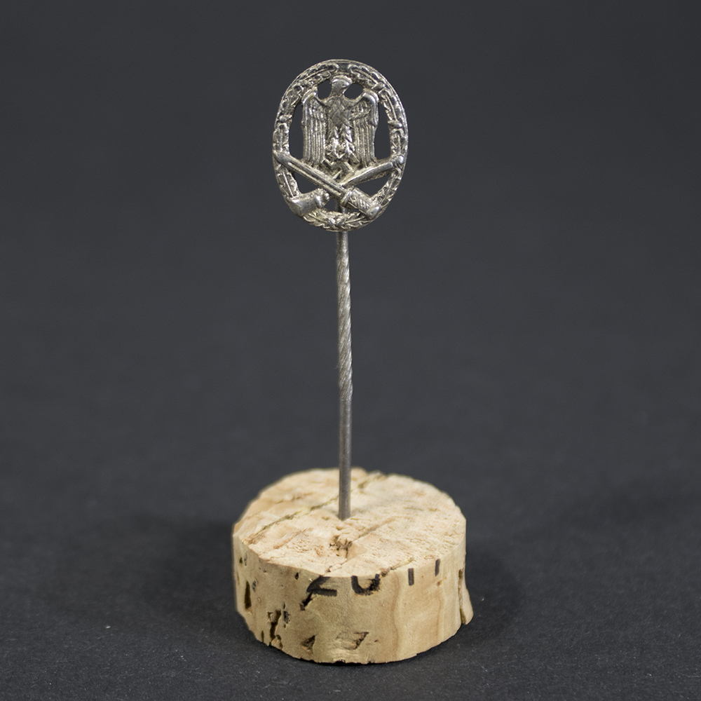 Complete view of the General Assault Badge stick pin, showing the long pin and miniature badge against a neutral background.