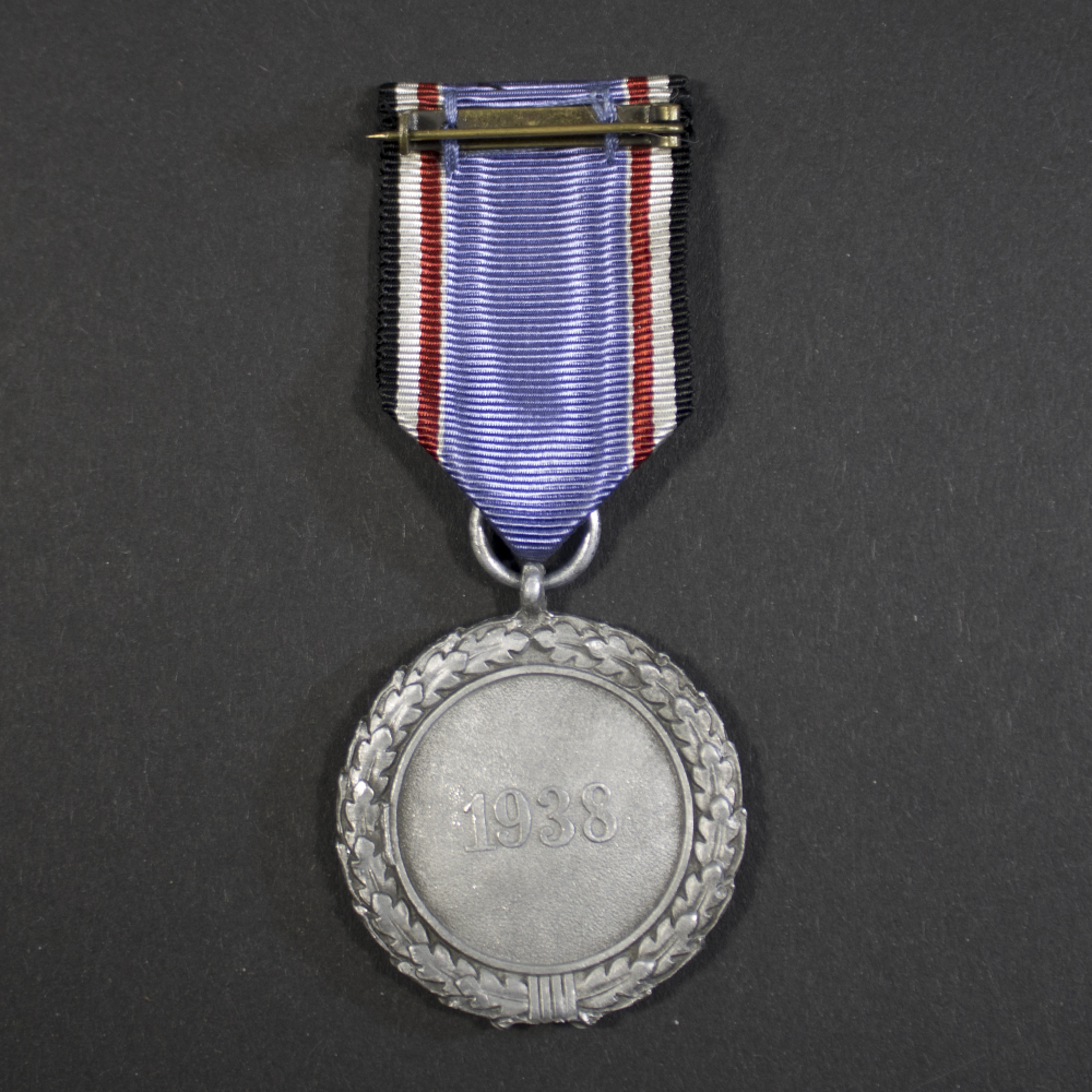Full back view of the Air Defence Medal, displaying the plain reverse side with suspension ring and attached ribbon.