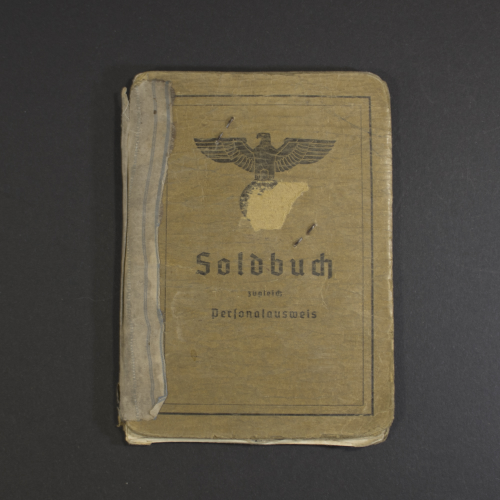 Front view of an original WWII German Soldbuch in heavily used condition, showing authentic cover details and wear.