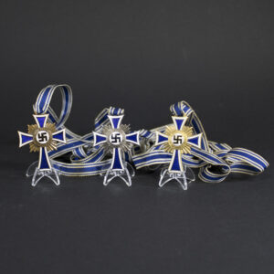 German Mother’s Cross set, featuring a white enamel cross with blue borders, a central swastika emblem, and the inscription ‘Der Deutschen Mutter’