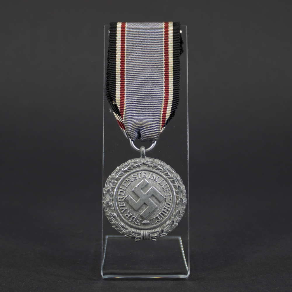 Front of a Luftschutz medal showing a swastika, surrounded by a laurel wreath border.”