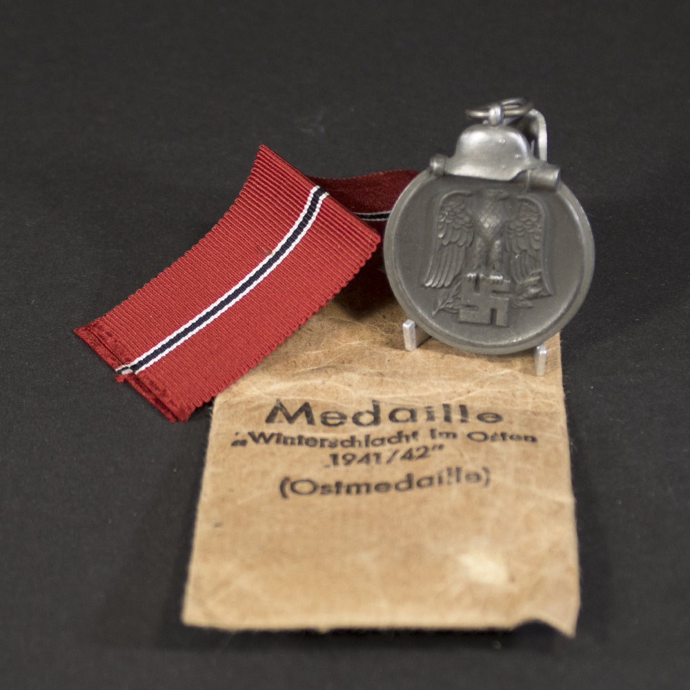 Eastern Front Medal with bag of issue displayed on a neutral background, showing the full medal with ribbon attached.