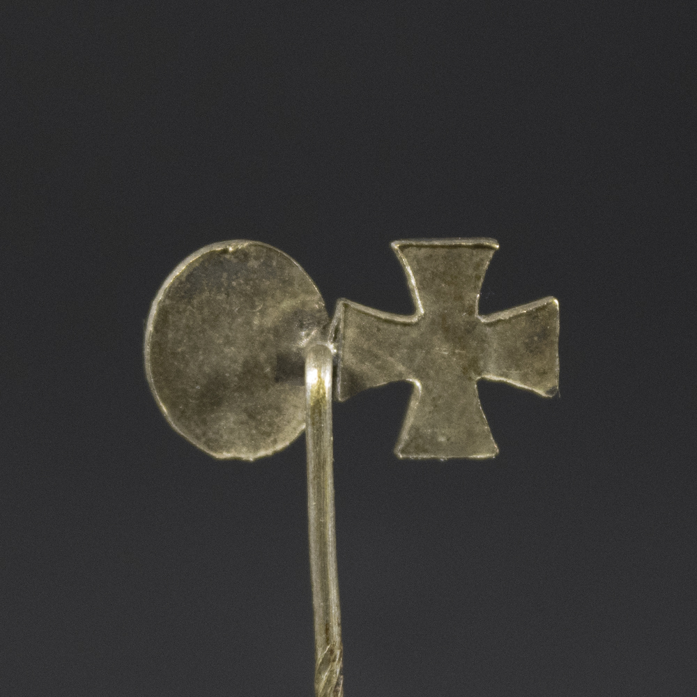 The reverse side of the stick pin shows a smooth metal surface with a simple pin attachment. No visible maker’s marks, but slight wear and patina are present.