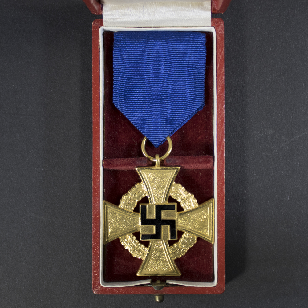 The front shows a German cross with a central swastika, surrounded by the inscription “Für treue Dienste” (For Faithful Service). The surface is slightly worn.