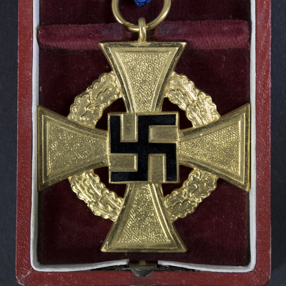 A detailed view of the cross design and inscription, highlighting the fine details and aged patina.