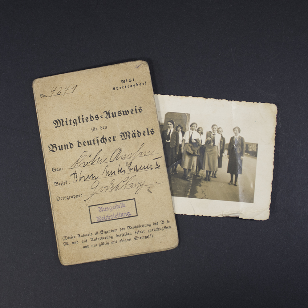 A flat lay showing the BDM membership pass and an additional photo placed beside it. The pass is closed, displaying its front cover design.