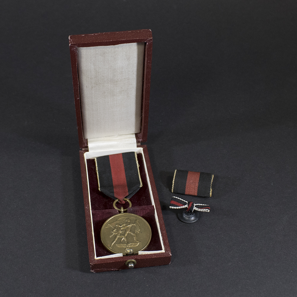 Cased German Sudetenland Medal from World War II, showing bronze medal with ribbon inside its original dark case.
