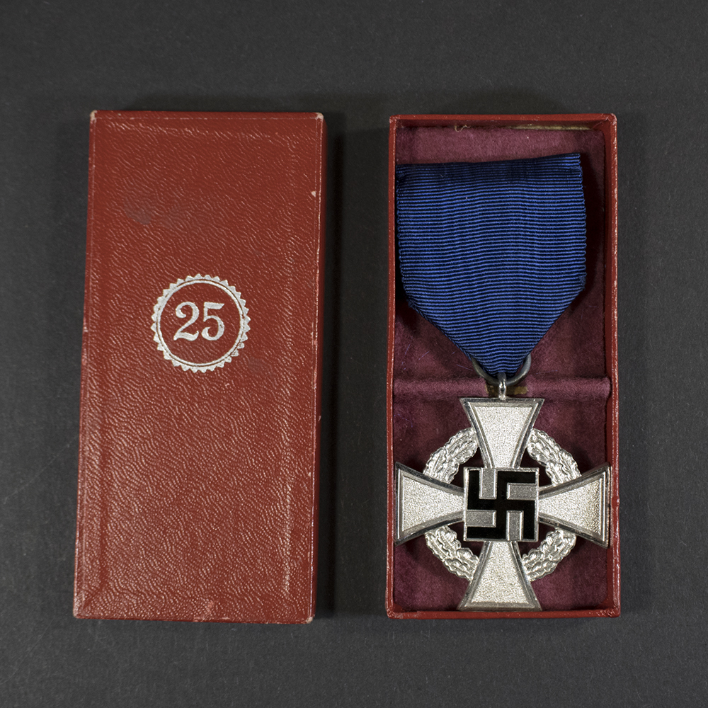 Front view of a German Faithful Service Medal, featuring a silver cross with a black enamel center, a swastika emblem, and the inscription ‘Für treue Dienste’ in Gothic script.