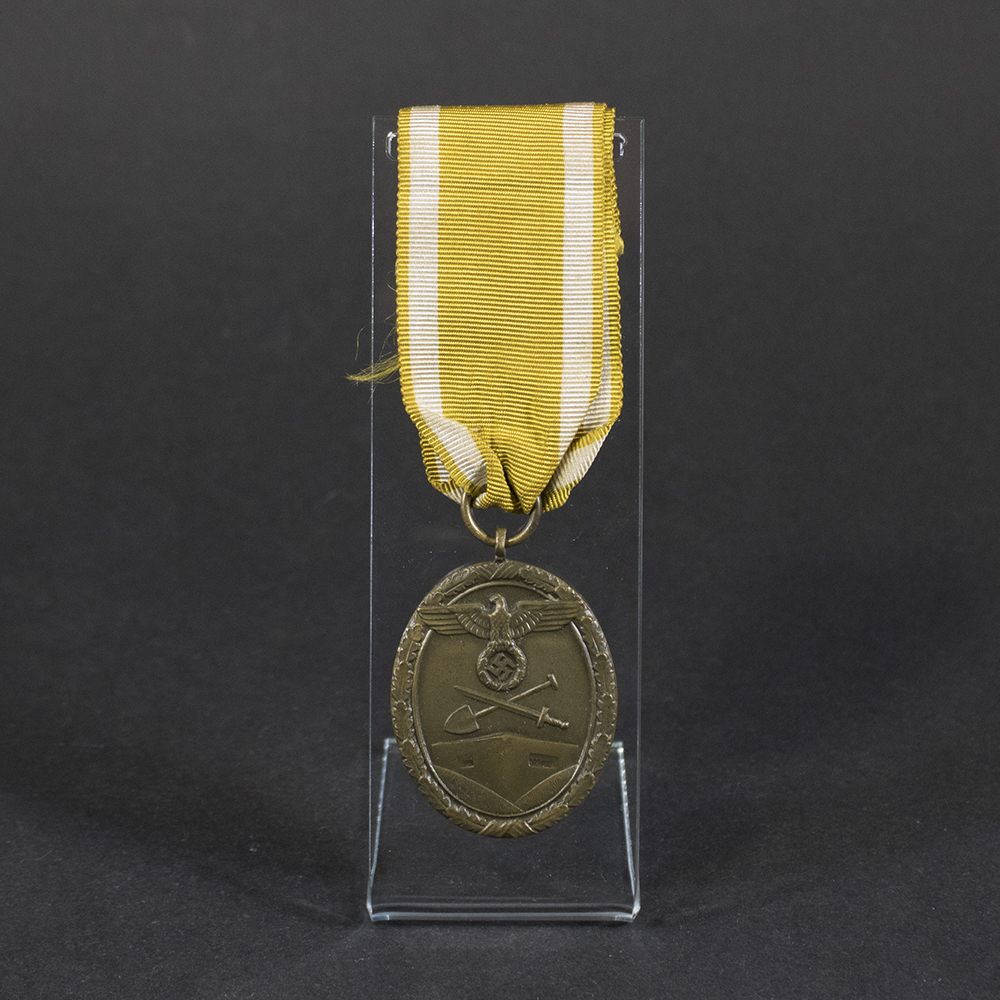 German Westwall Medal from World War II, bronze-colored circular medal with ribbon displayed