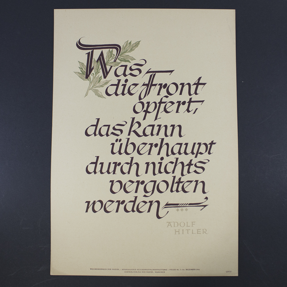 "Front of an NSDAP Wochenspruch poster featuring bold blackletter German text centered on a plain background. The quote is framed by a simple border, with the party emblem (swastika) in the lower corner. The design is minimalistic, emphasizing the ideological message."