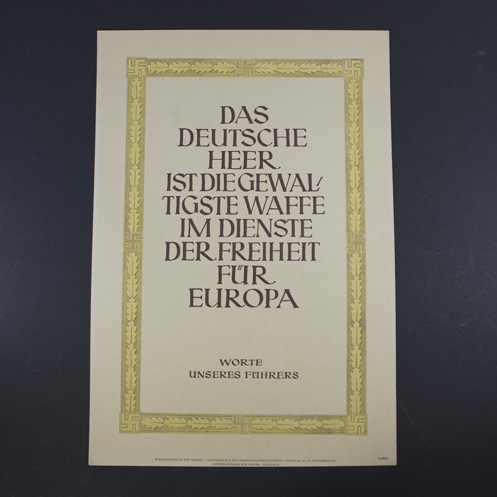 Front of an NSDAP Wochenspruch poster featuring bold blackletter German text centered on a plain background. The quote is framed by a simple border, with the party emblem (swastika) in the lower corner. The design is minimalistic, emphasizing the ideological message.