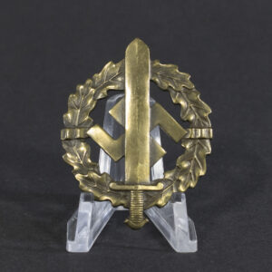 A World War II-era German SA sports badge made of bronze, featuring an oval wreath with a sword running vertically through the center and the letters ‘SA’ prominently displayed