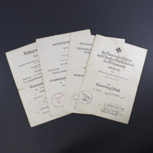 Full view of a set of four World War II German award documents arranged side by side, including wound badge certificates, Eastern Front Medal certificate, and Iron Cross 2nd Class certificate.