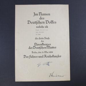 Front view of a World War II German award document for the Bronze Mother’s Cross, featuring printed German text in Gothic script, official stamp, and handwritten signature.