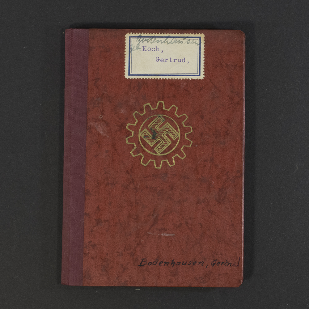 Front cover of a World War II German DAF membership book, featuring the organization’s emblem and German text printed on a textured surface.