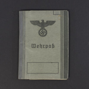 Front cover of a World War II German Wehrpass, showing the gray textured surface with the eagle and swastika emblem above the word ‘Wehrpass.
