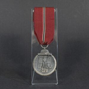 Full view of a World War II German Eastern Front Medal, showing its oval shape with a suspension ring and darkened finish.