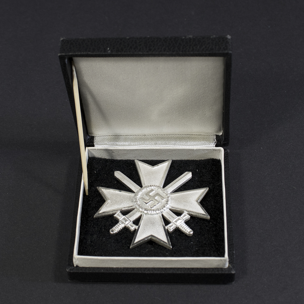 Full view of a World War II German War Merit Cross 1st Class with swords displayed inside its original black presentation case with velvet lining.
