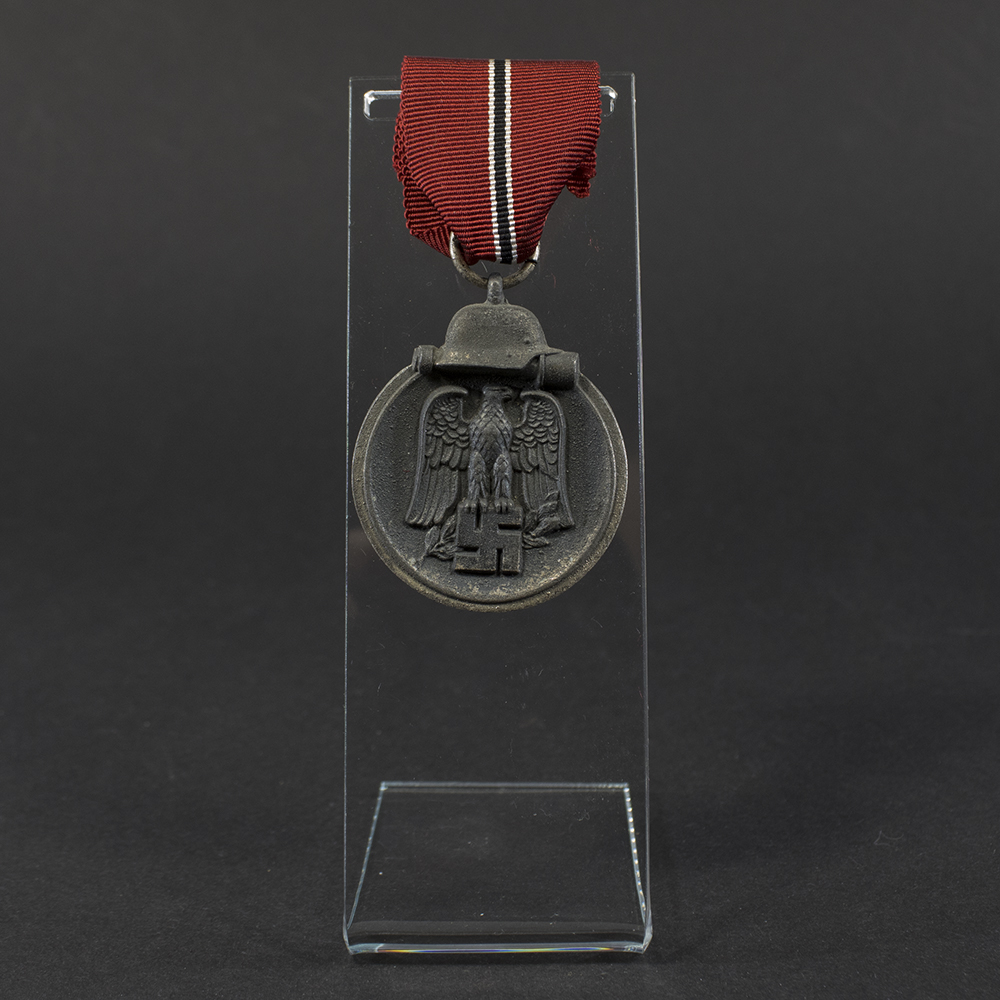 World War II German Eastern Front Medal displayed flat, showing its oval shape with a loop at the top and detailed embossed design