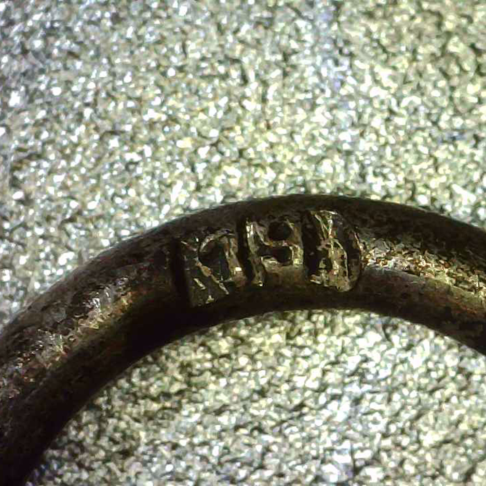 Detailed view of the suspension ring on the medal, highlighting the stamped maker’s mark ‘19’ engraved inside the ring.
