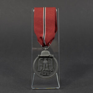 World War II German Eastern Front Medal displayed flat, showing its oval shape with a loop at the top and detailed embossed design.