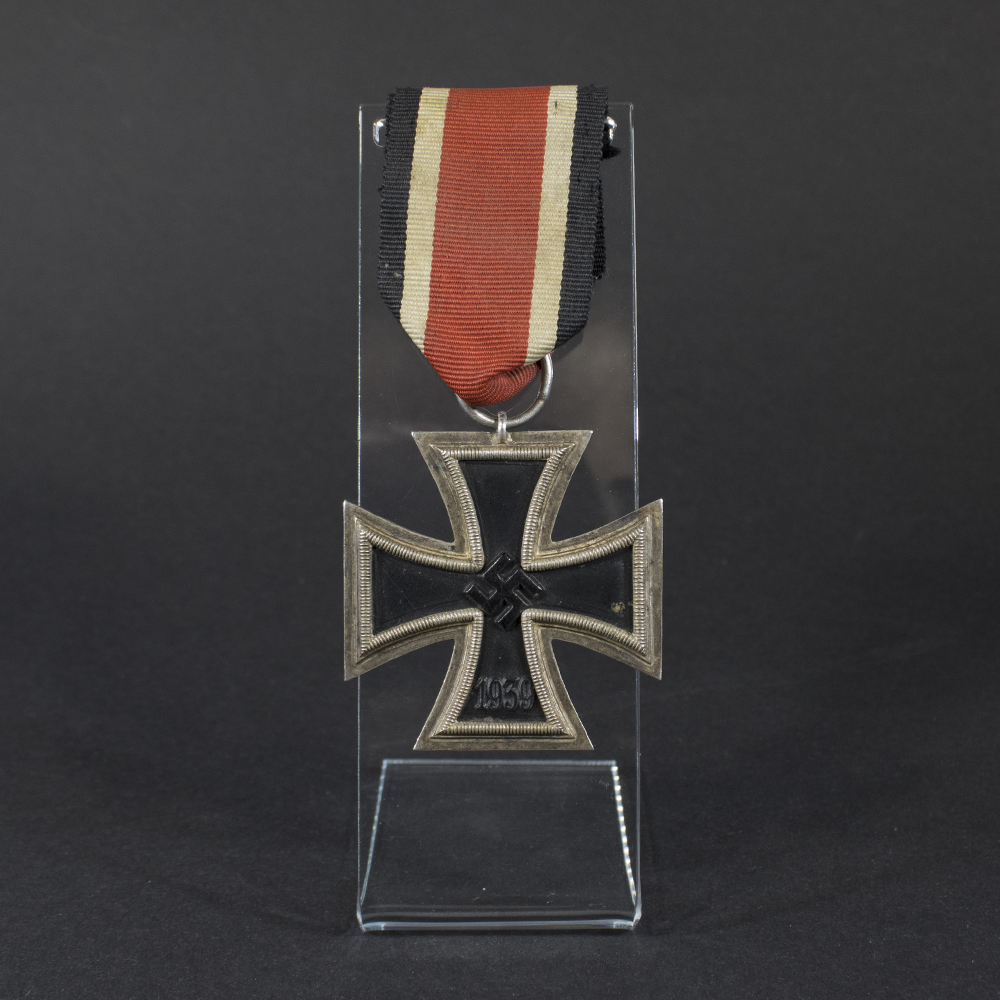 World War II German Iron Cross displayed on a flat surface, showing its black core and silver frame.