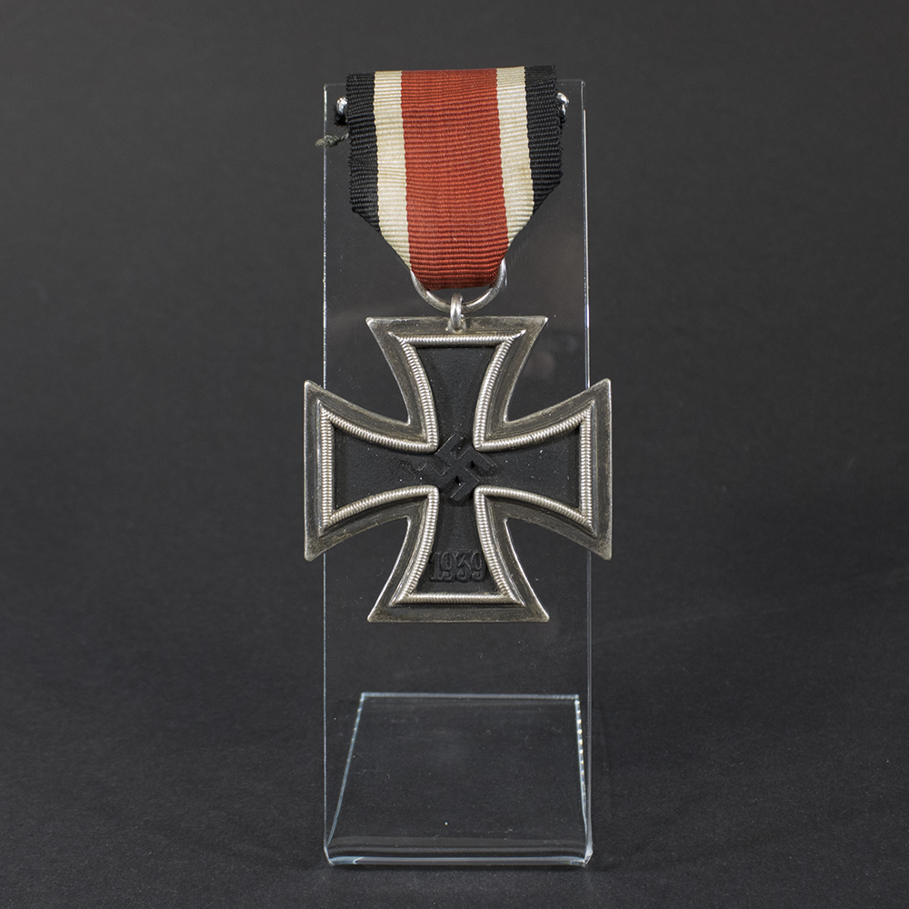 World War II German Iron Cross displayed on a flat surface, showing its black core and silver frame