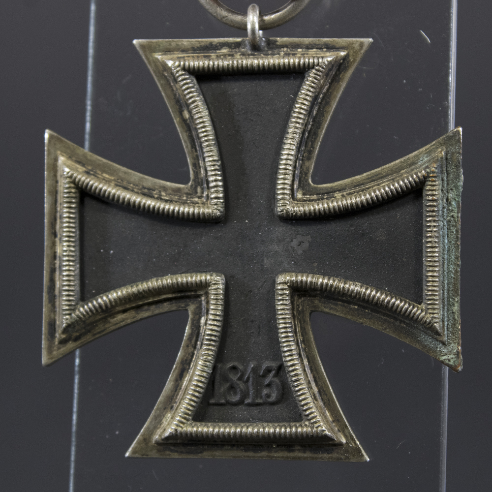 Back side of the WWII German Iron Cross 2nd Class medal, showing plain silver frame and black core with smooth finish