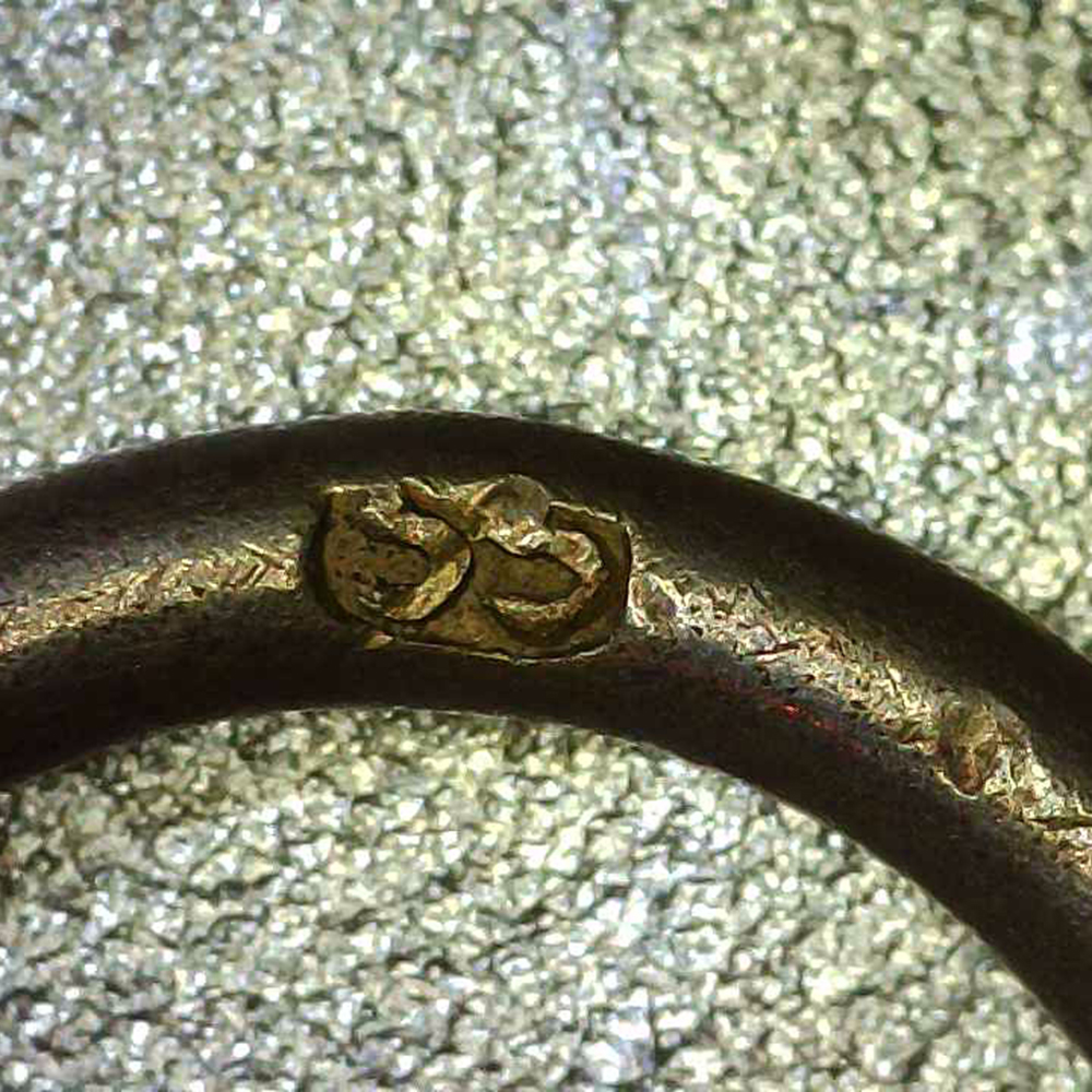 Detailed view of the suspension ring on the medal, highlighting the stamped maker’s mark ‘55’ engraved inside the ring.