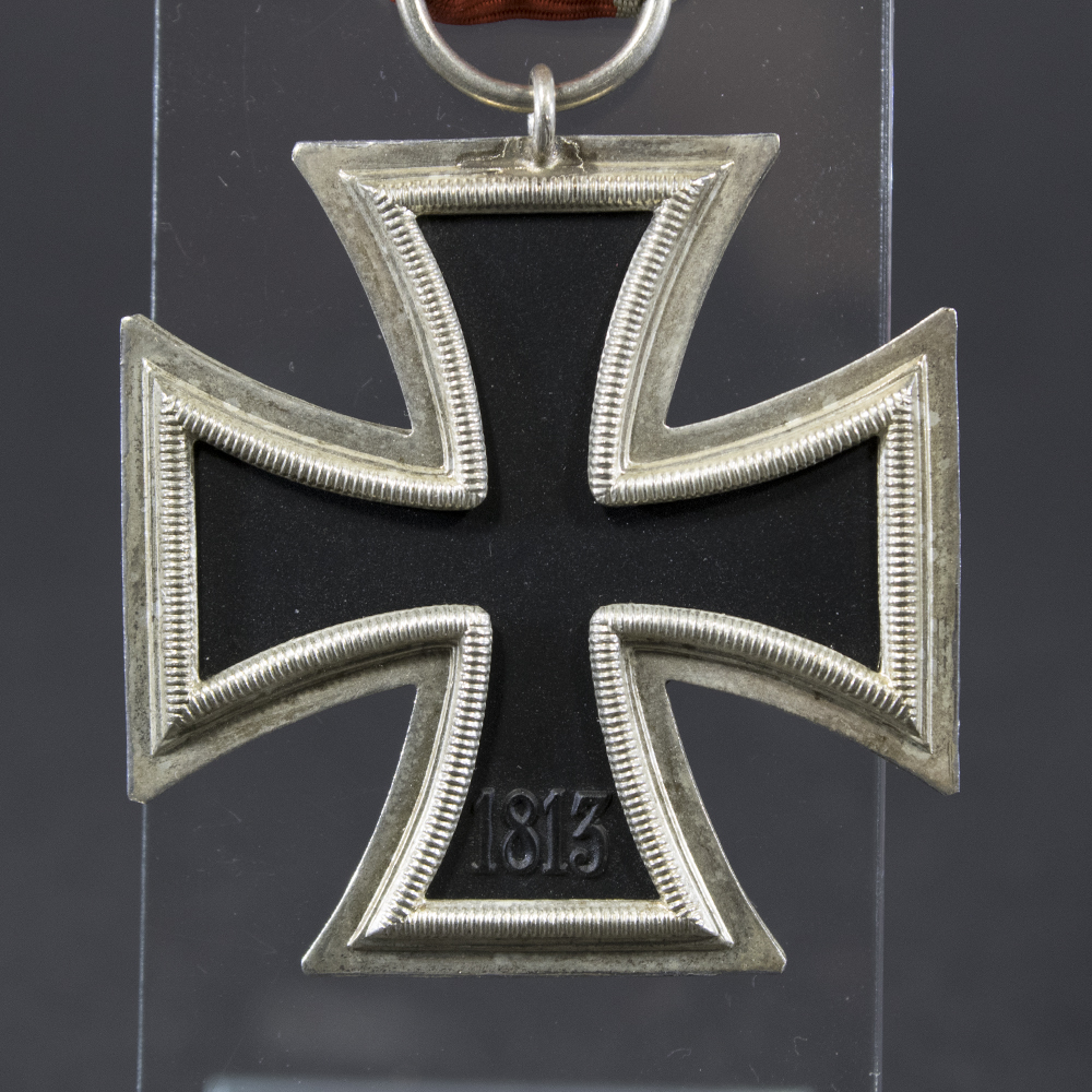 Back side of the WWII German Iron Cross 2nd Class medal, showing plain silver frame and black core with smooth finish.