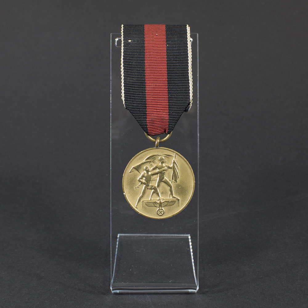 World War II German Sudeten Occupation Medal displayed on a flat surface, showing its circular design and ribbon.