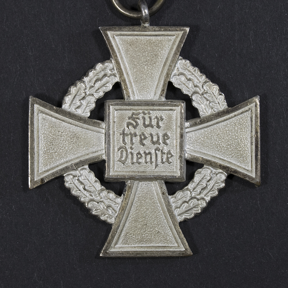 Close-up of the reverse of a WWII German 25 Years Faithful Service Medal, displaying the inscription and surface wear.