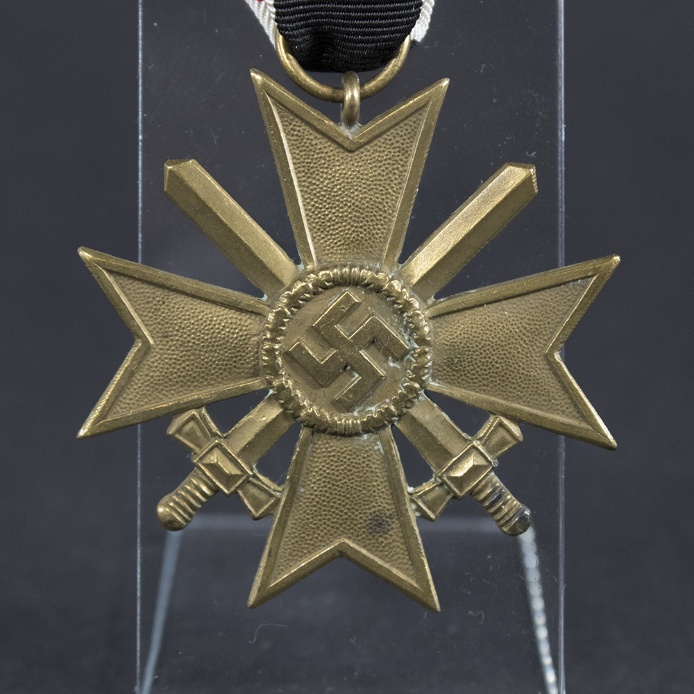 Close-up of the front of a WWII German War Merit Cross with Swords, showing the central emblem and detailed metalwork.