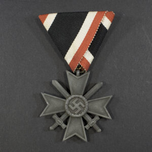 World War II German War Merit Cross 2nd Class with swords and Austria fold ribbon displayed on a flat surface, showing the front design.