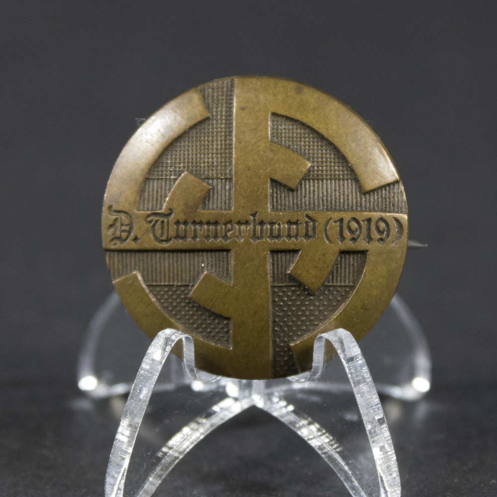 Front side of the Deutscher Turnerbund 1919 pin, showing the detailed emblem and inscription.