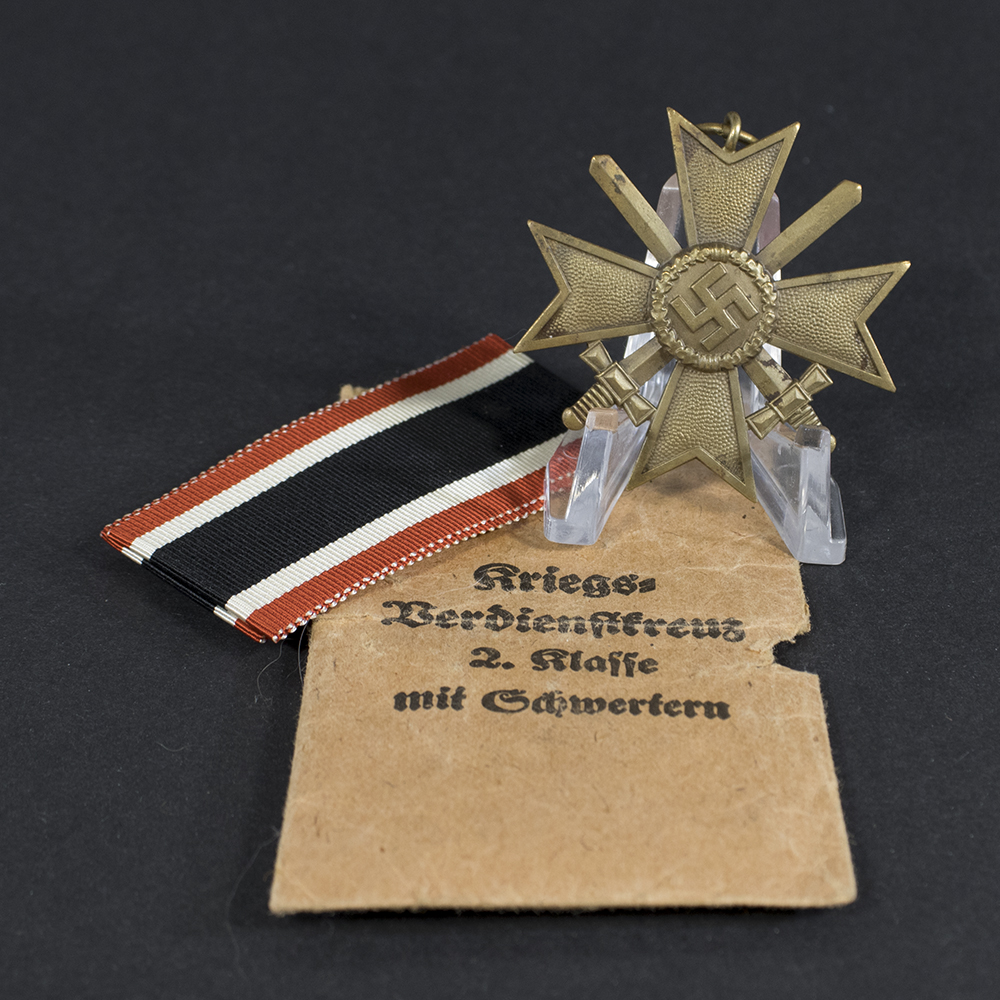 Overview of a WWII German War Merit Cross with Swords set, showing the medal displayed alongside its original issue bag.