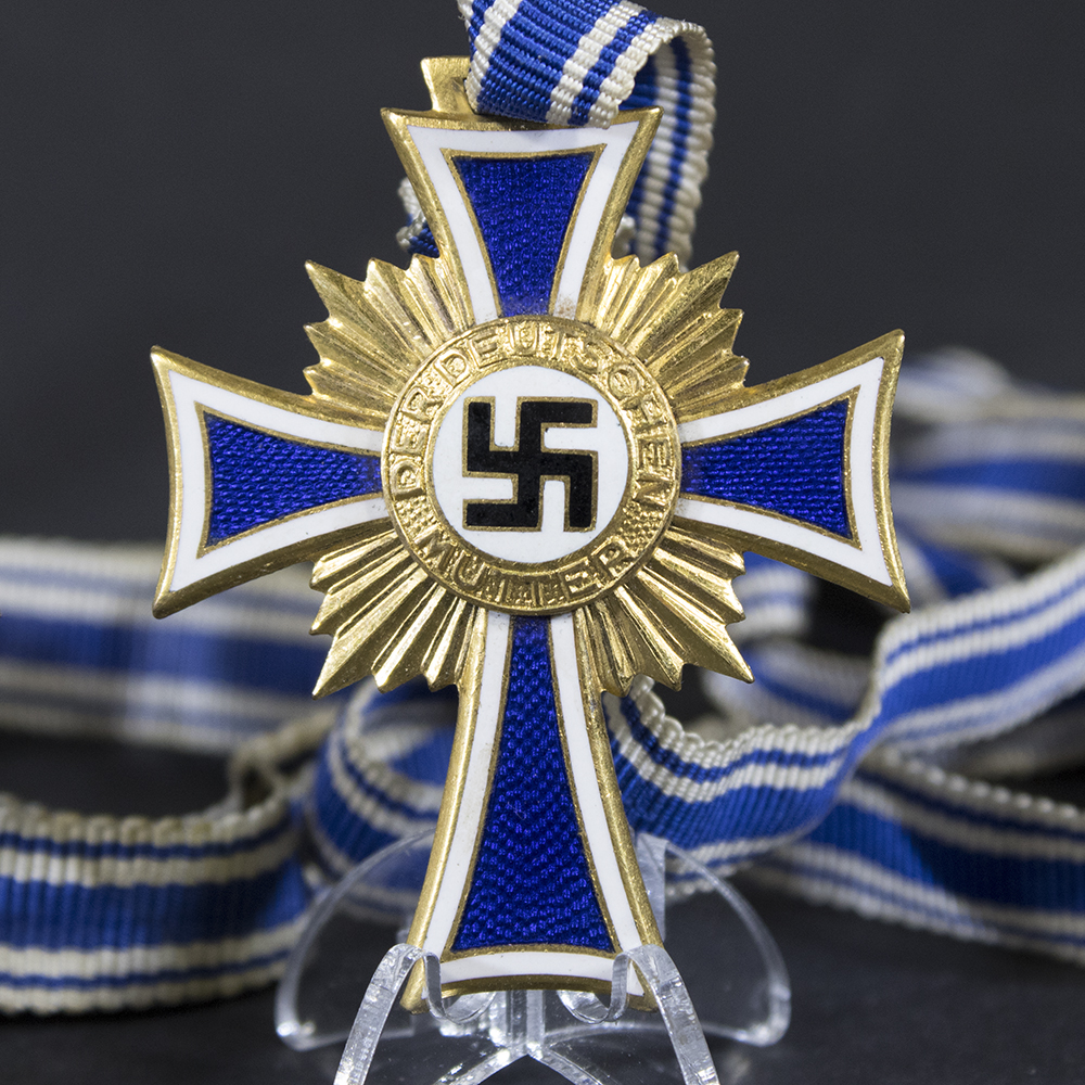 Front side of the gold Mother’s Cross, featuring the bright enamel design with swastika emblem and decorative border.