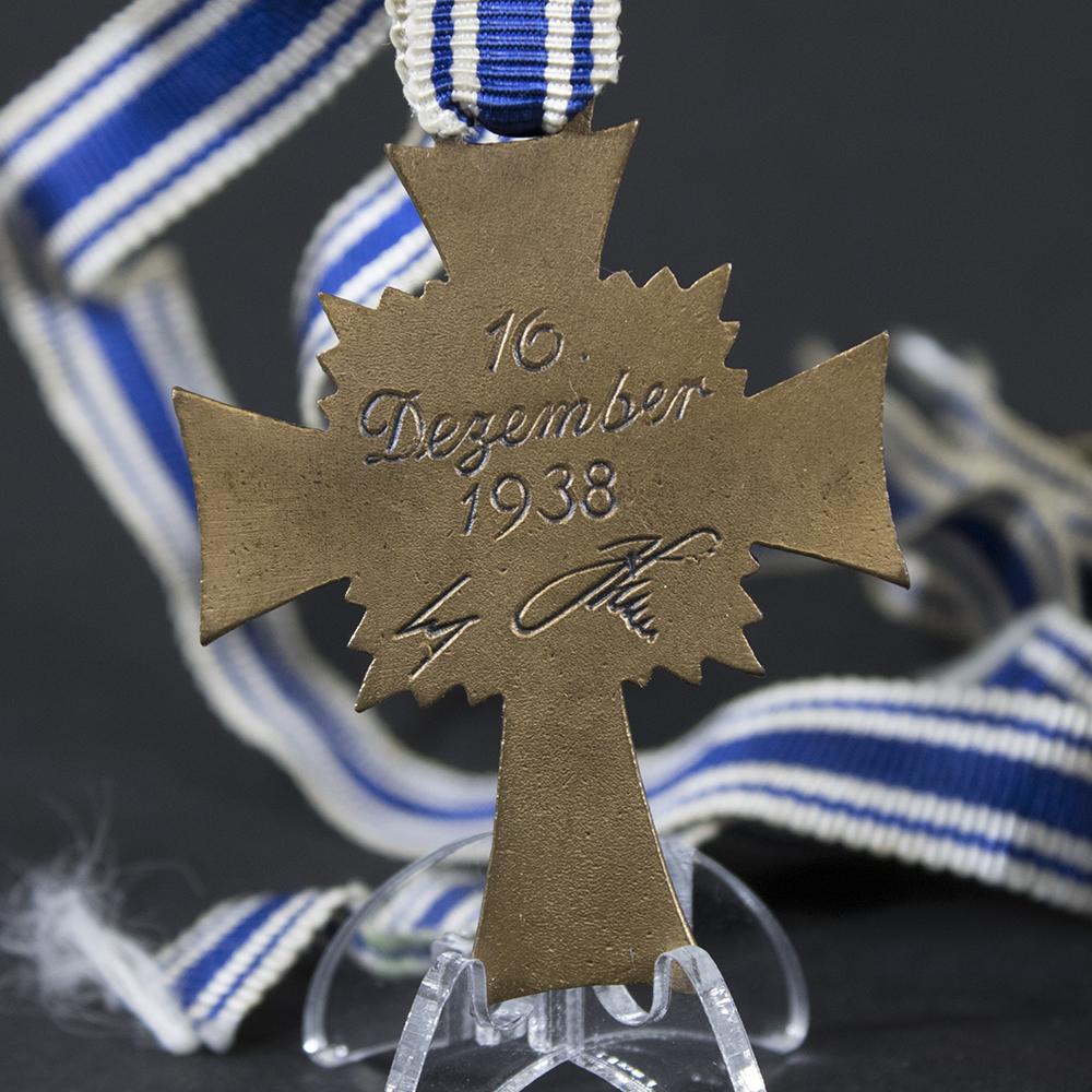Reverse side of the bronze Mother’s Cross, featuring the engraved dedication and smooth metal surface.