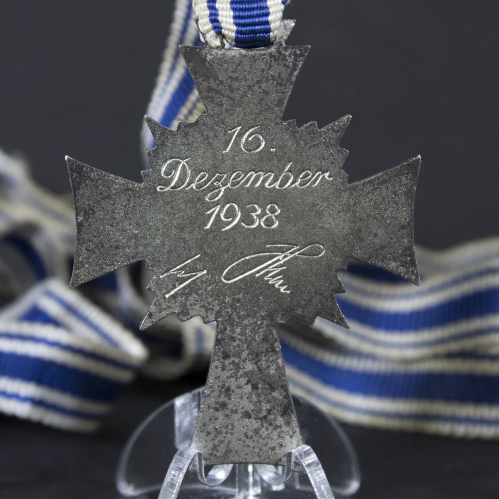 Reverse side of the silver Mother’s Cross, showing the engraved inscription and polished finish
