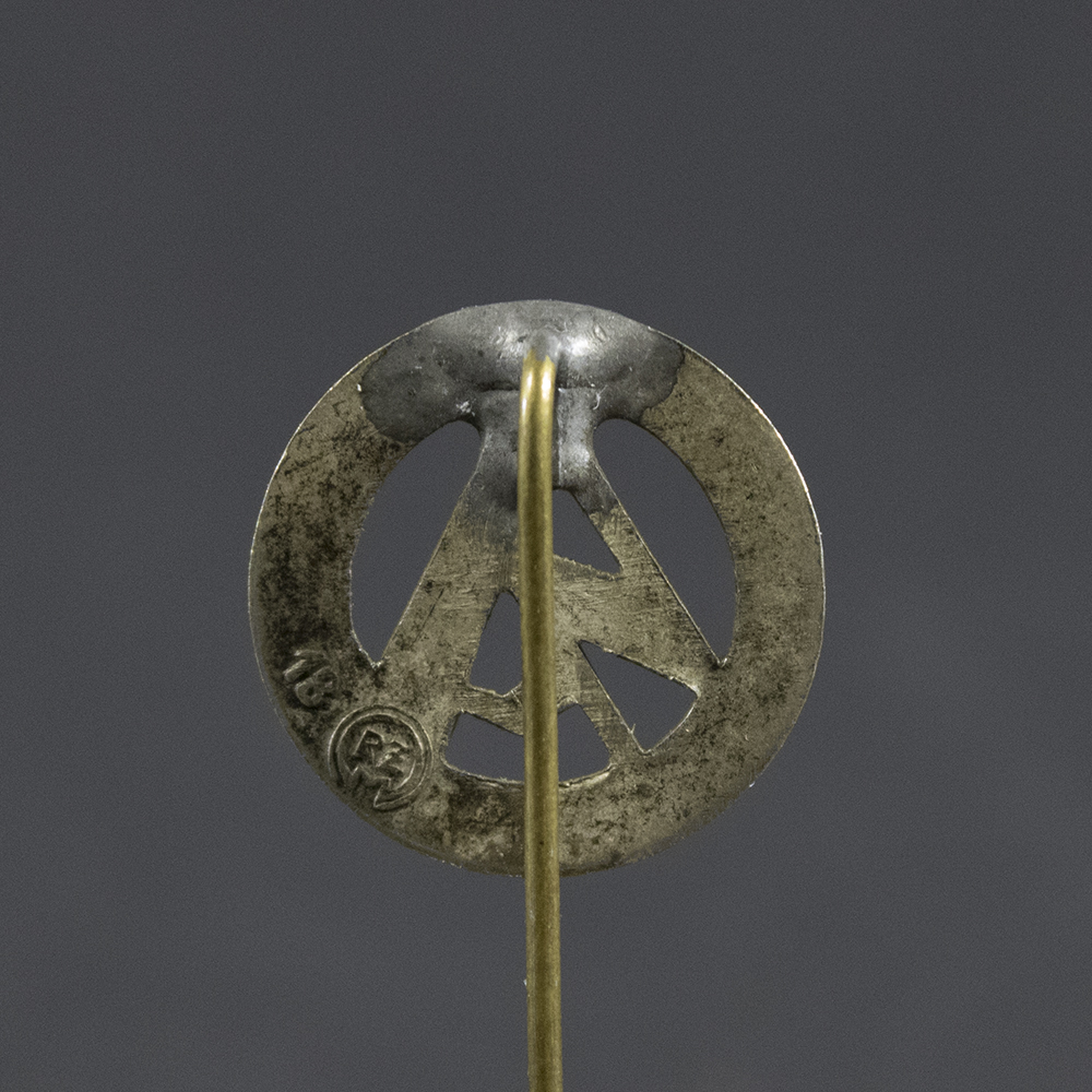 Close-up of the reverse of a WWII German SA membership stick pin, showing the plain metal back and fastening post.