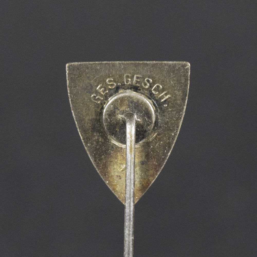 Back side of the WWII German Kyffhäuserbund membership stick pin, showing the smooth reverse surface and the pin attachment extending downward.