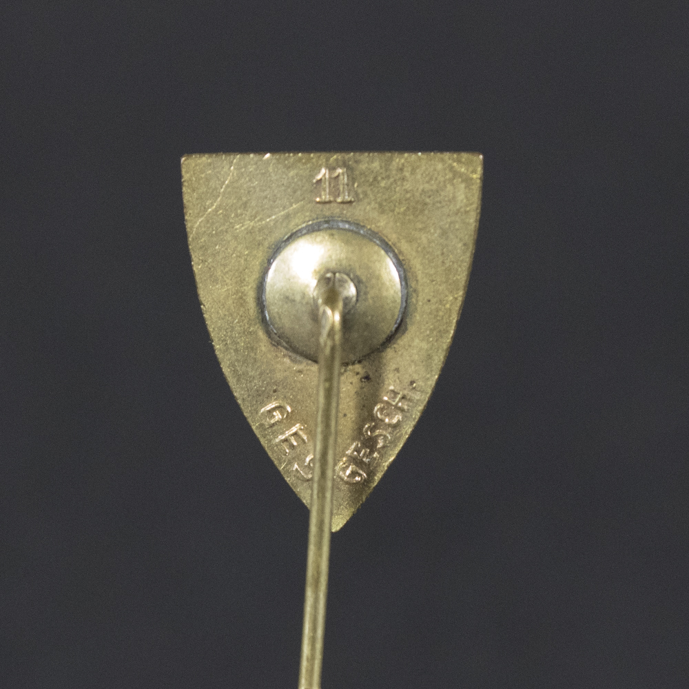 Back side of the WWII German Kyffhäuserbund membership stick pin, showing the smooth reverse surface and the pin attachment extending downward.