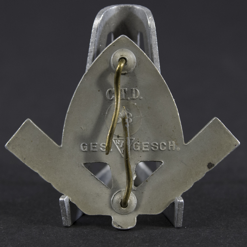 Close-up of the reverse of a WWII German RAD cap badge, showing the fastening prongs and metal construction.